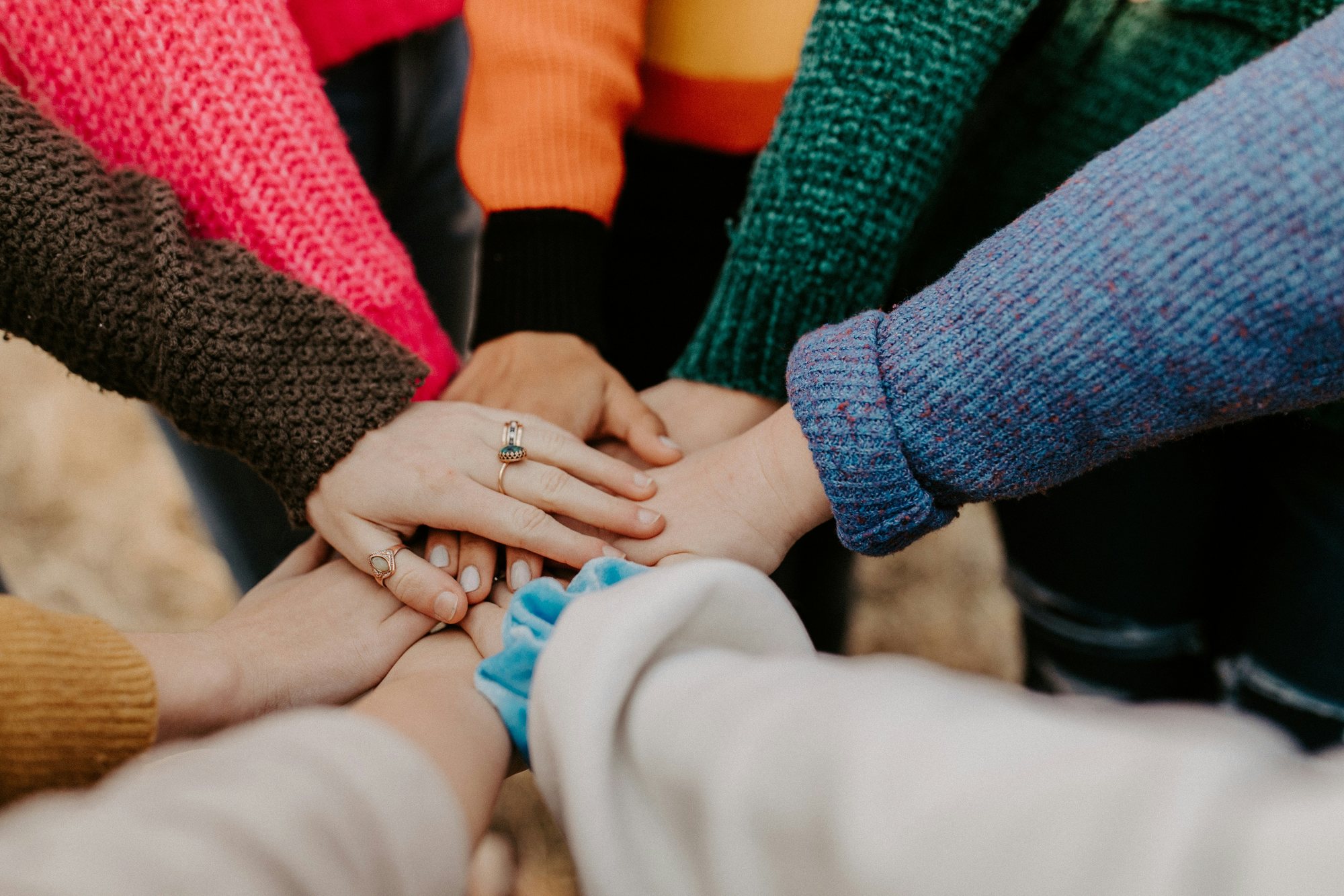 Hands of many people stacked together in a circle
